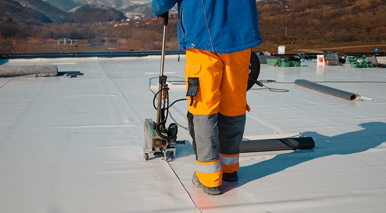 A Contractor Waterproofing a Roof