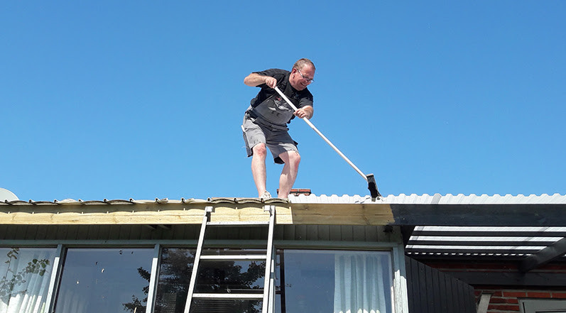 A Man Cleaning a Roof