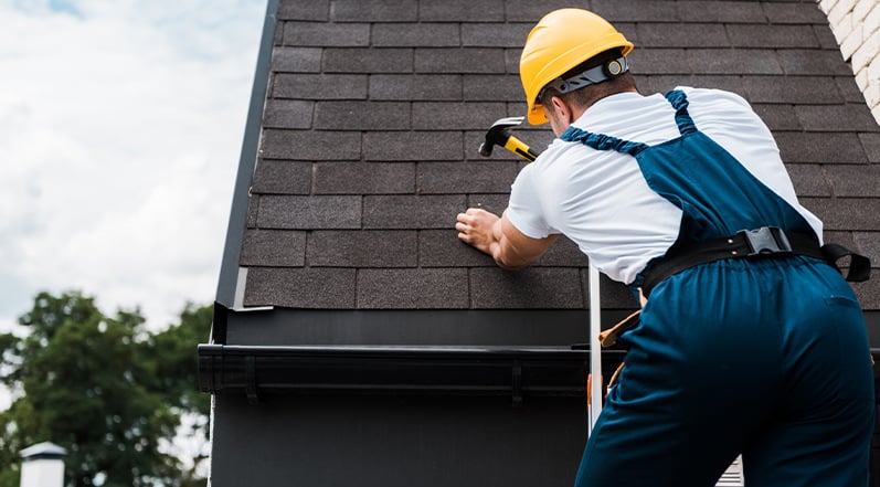 A Roofing Contractor Repairing Roof Shingles