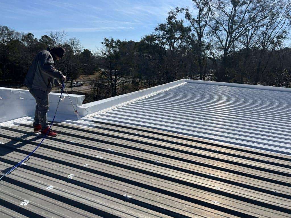 This image shows the process of roof coating on a metal roof.